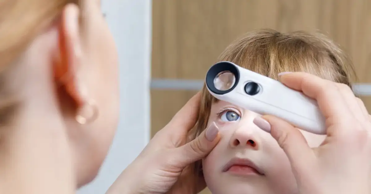 Badanie wzroku dziecka przy użyciu oftalmoskopu.