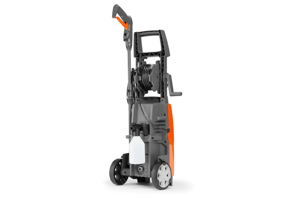 Myjka ciśnieniowa Husqvarna PW 125 z wężem i zbiornikiem na detergent, gotowa do pracy.