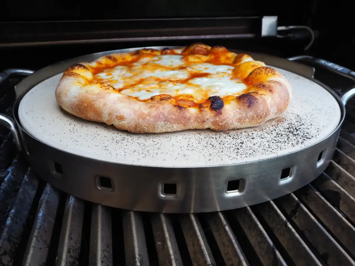 Pyszna pizza z grilla gazowego, z rumianym ciastem i ciągnącym się serem, pieczona na kamieniu.