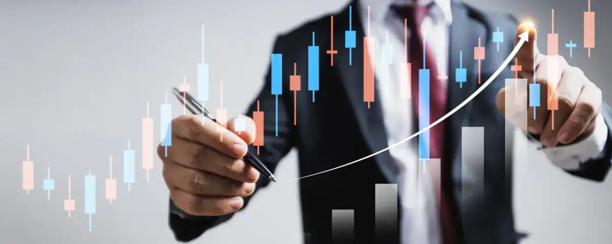 Biznesmen analizuje wykresy giełdowe, wskazując na wzrost. To pokazuje, co to jest fundusz powierniczy – narzędzie do zarządzania aktywami.