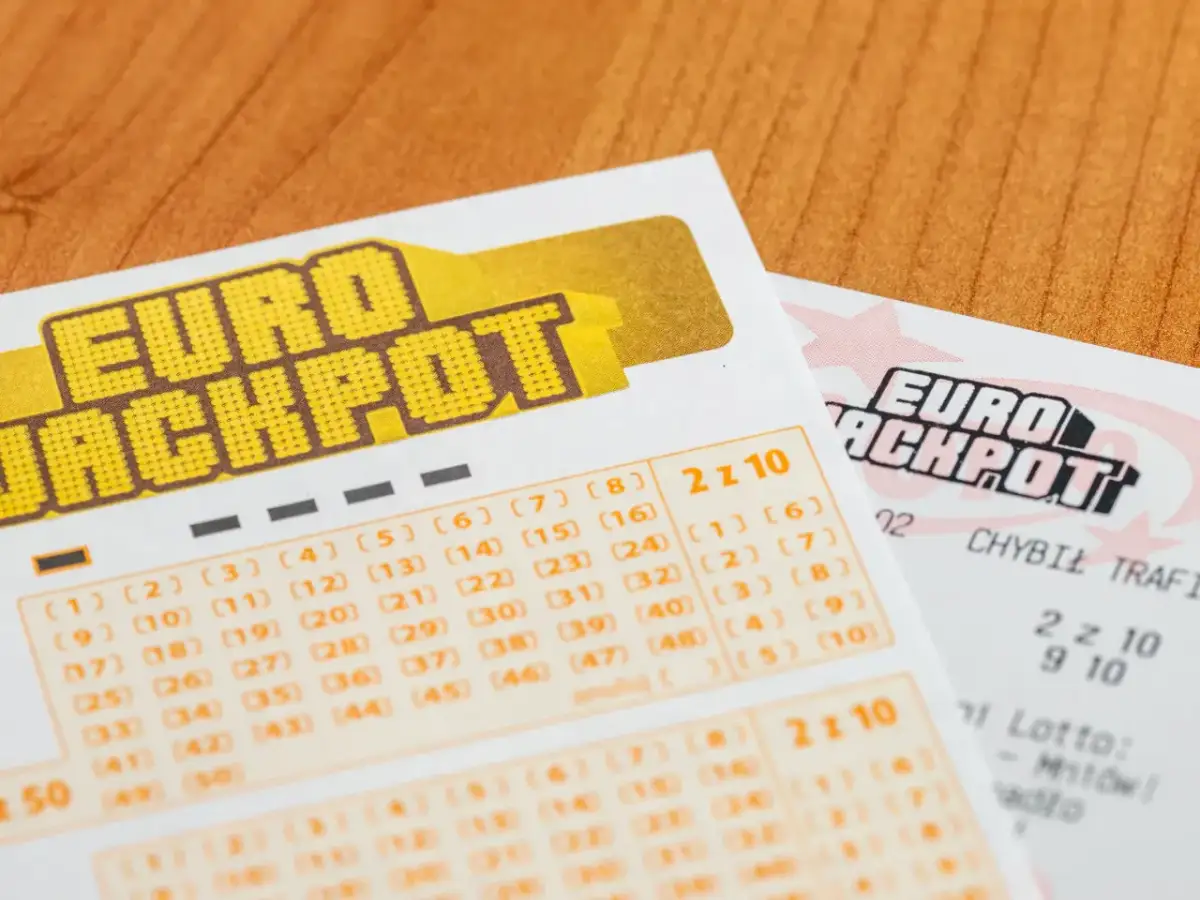 Kupony gry liczbowej Eurojackpot na drewnianym tle.