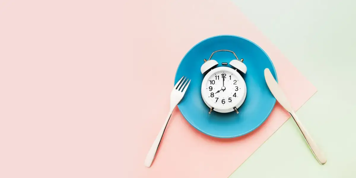 Budzik na talerzu z widelcem i nożem. Czas na post 36 godzinny.