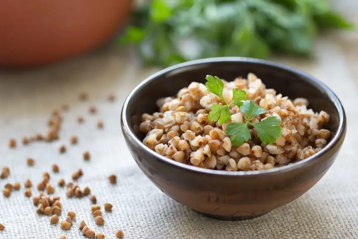 Miseczka pełna kaszy gryczanej, ozdobiona natką pietruszki. Idealna do obiadu, a jej przygotowanie jest proste. Dowiedz się, ile gotować kaszę gryczaną w woreczku.