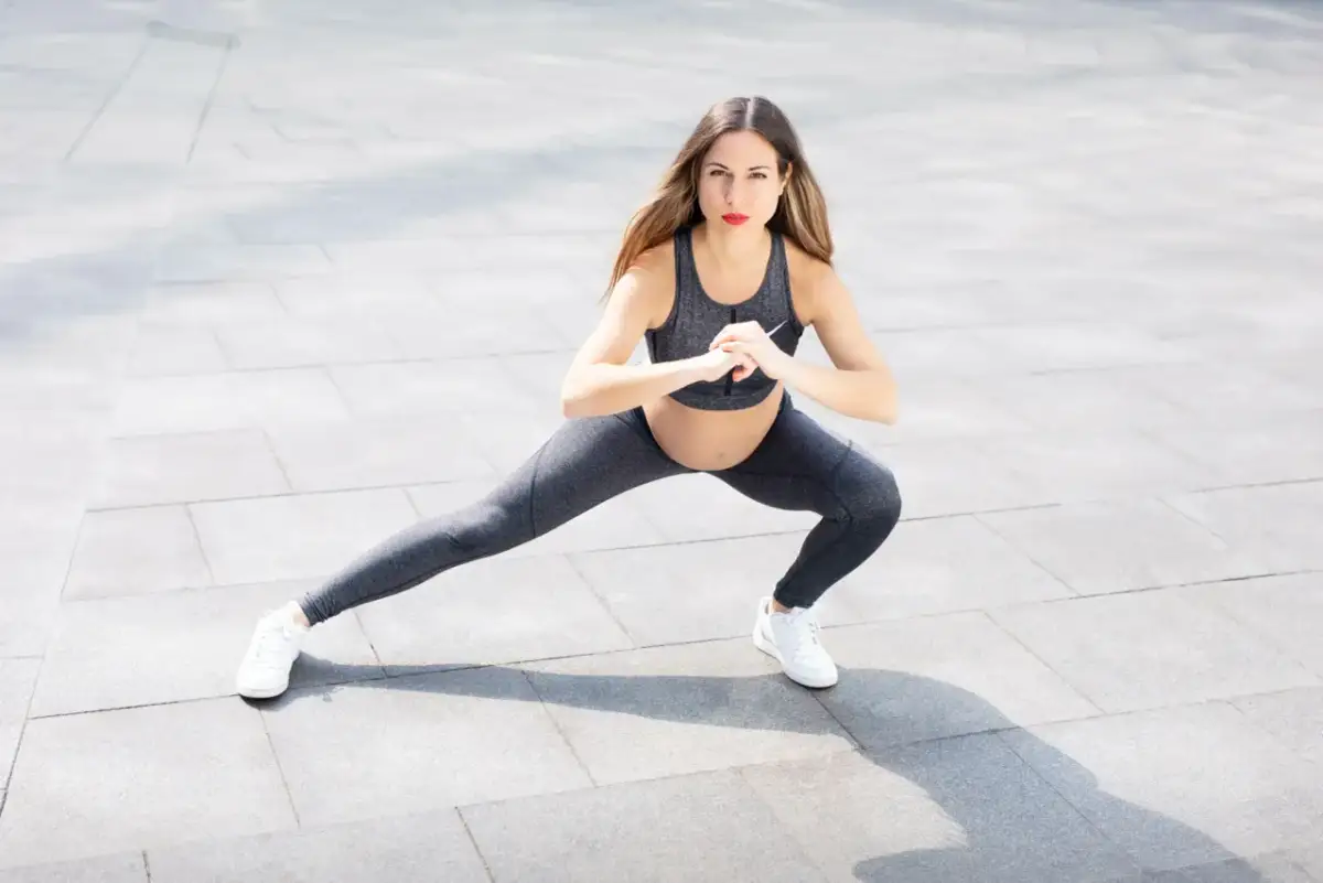 Kobieta w ciąży wykonuje wykroki, pokazując jakie ćwiczenia podczas okresu są bezpieczne i korzystne dla zdrowia.