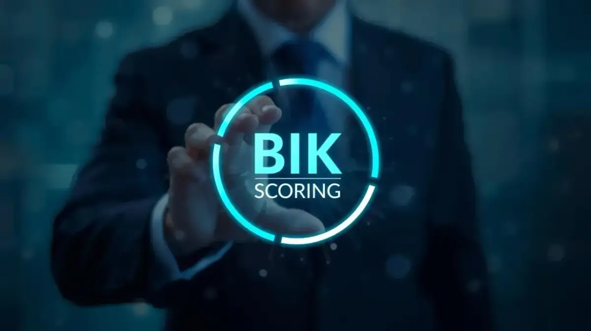 Dłoń w garniturze dotyka interfejsu, gdy bik aktualizuje dane. Widoczny napis "BIK SCORING" w neonowym okręgu.
