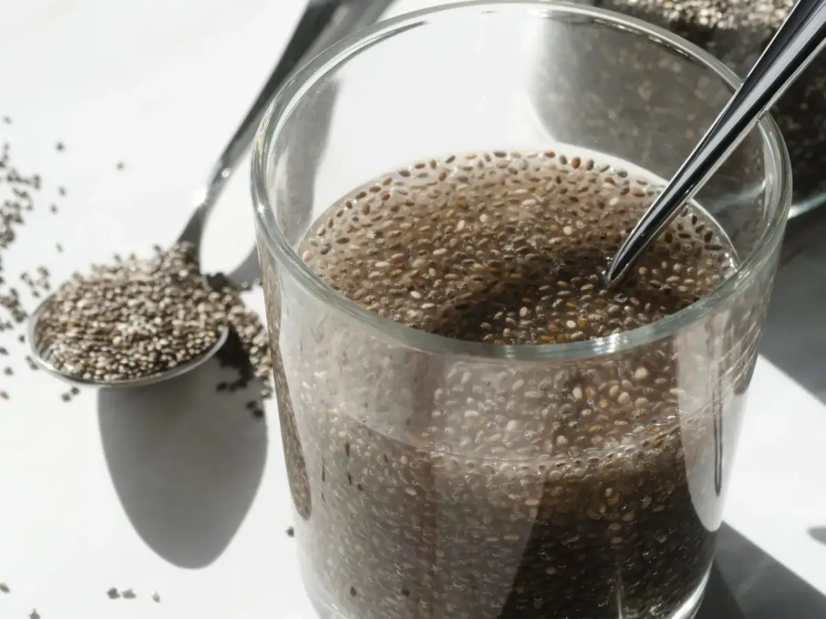 Nasiona chia pęczniejące w wodzie, łyżka pełna nasion. Prosty sposób, jak przygotować nasiona chia.