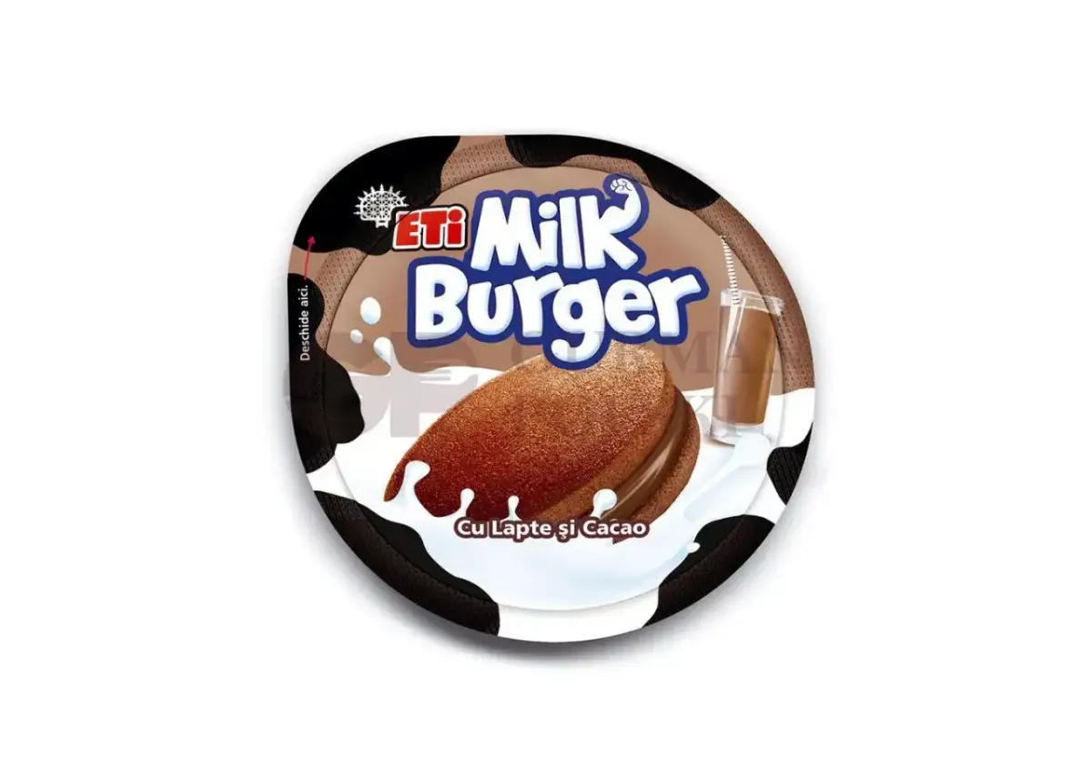 Czekoladowe ciastko Milk Burger z kremem, oblane mlekiem, obok szklanki mleka czekoladowego.