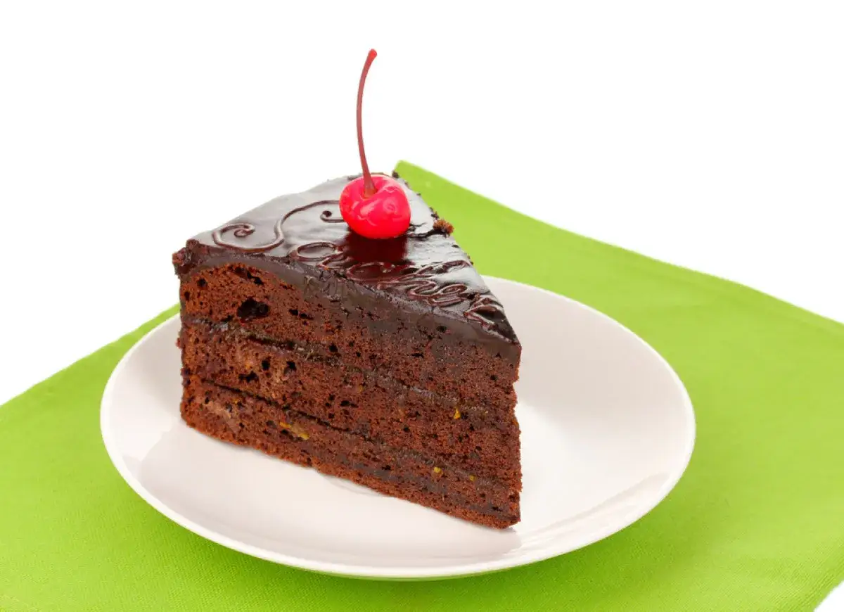 Pyszny kawałek tortu czekoladowego z wiśnią na wierzchu. Zastanawiasz się, ile kalorii ma taki kawałek tortu czekoladowego?