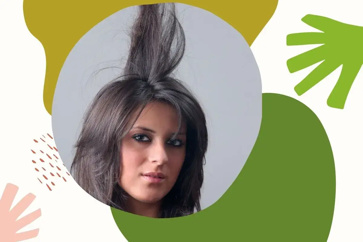 Kobieta z elektryzującymi się włosami, które sterczą do góry. Tło abstrakcyjne.