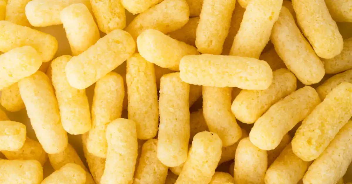 Zbliżenie na chrupki kukurydziane, żółte, podłużne paluszki.