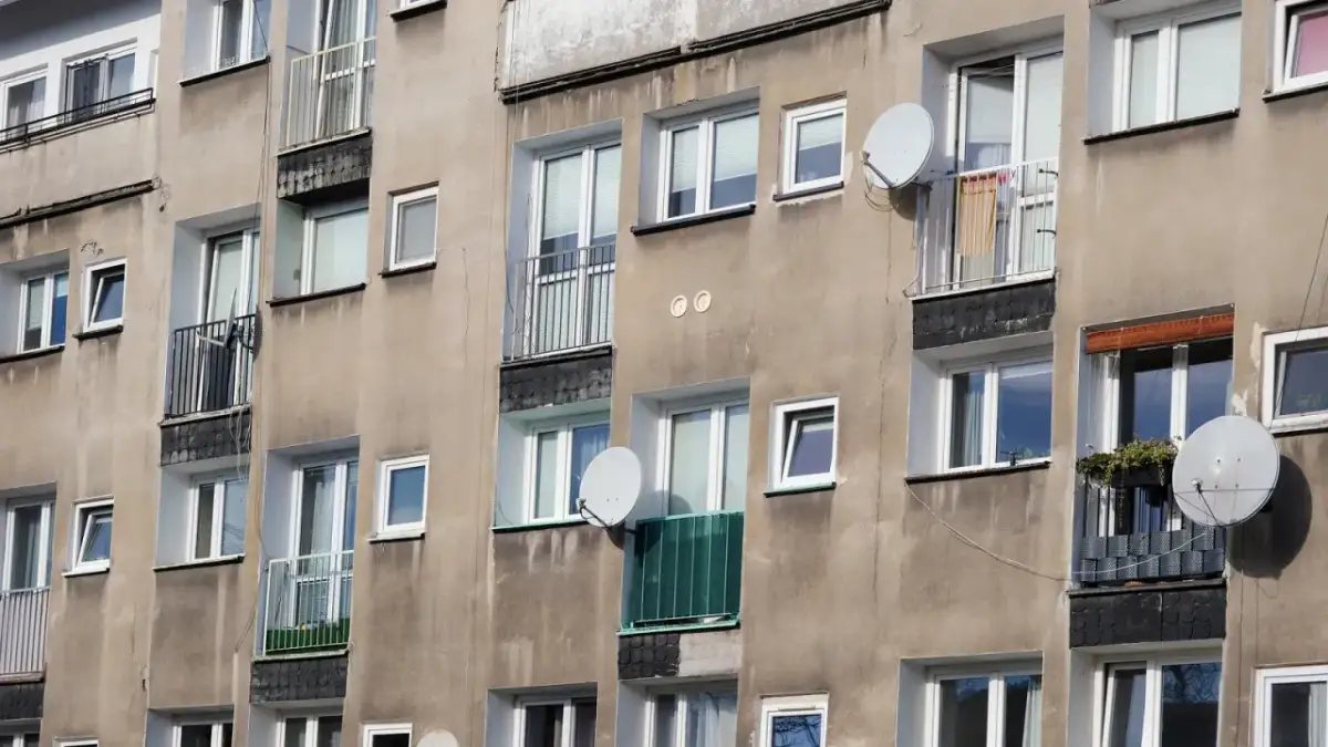 Szare bloki mieszkalne z balkonami i antenami satelitarnymi. Czy wojsko daje mieszkanie w takich budynkach?