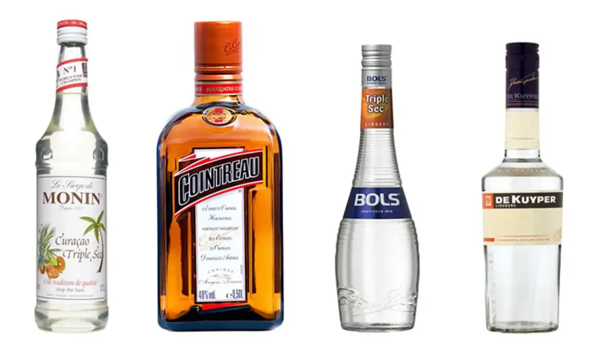 Cztery butelki likierów: Monin, Cointreau, Bols Triple Sec i De Kuyper. Cointreau to znany likier pomarańczowy, a Bols Triple Sec to jego tańsza alternatywa.