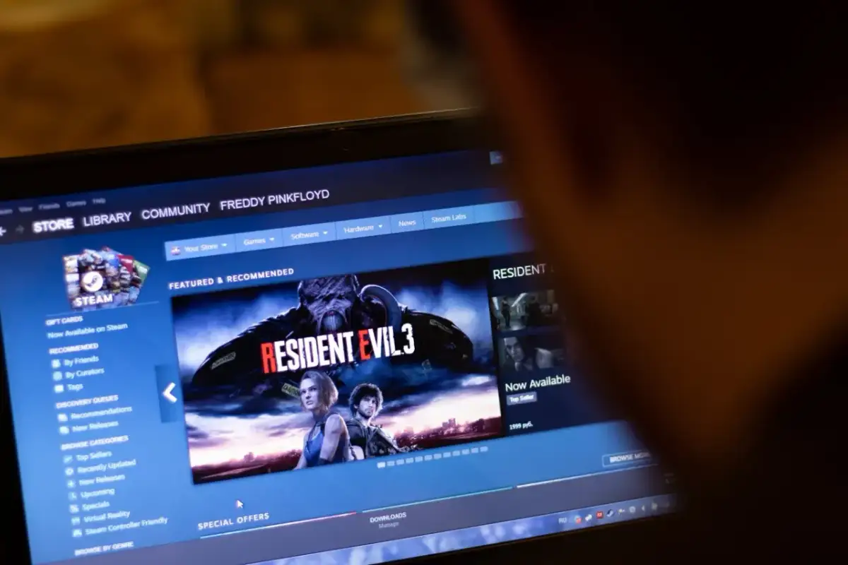 Ekran laptopa z interfejsem sklepu Steam, widoczna okładka gry Resident Evil 3.