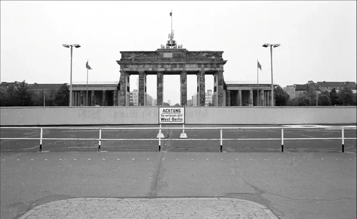 Brama Brandenburska z tablicą "ACHTUNG Sie verlassen jetzt West-Berlin", symbolizująca czas, kiedy powstał mur berliński.