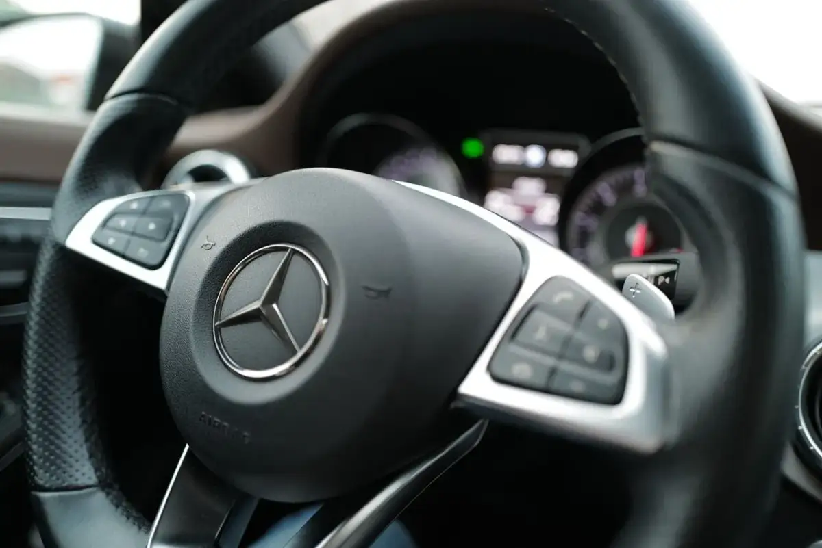 Kierownica Mercedesa z przyciskami i łopatkami zmiany biegów. Brak luzów na kierownicy, gotowa do jazdy.