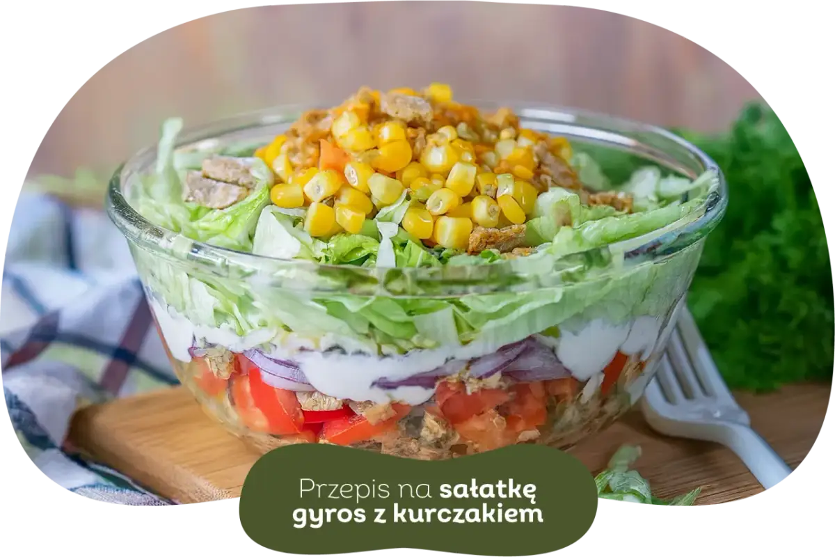 Warstwowa sałatka gyros z kurczakiem, pomidorami, cebulą i kukurydzą. Idealna, gdy zastanawiasz się, czy sałatkę gyros można zrobić dzień wcześniej.