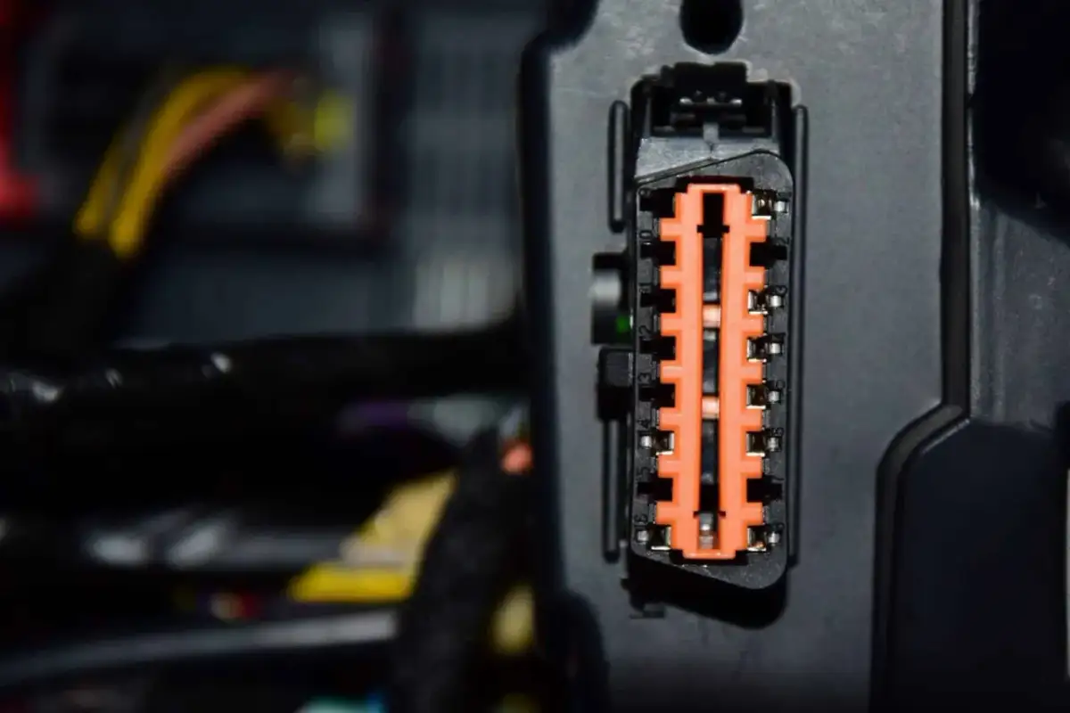 Pomarańczowe złącze diagnostyczne w samochodzie, gotowe do podłączenia, by sprawdzić ewentualne błędy w aucie.