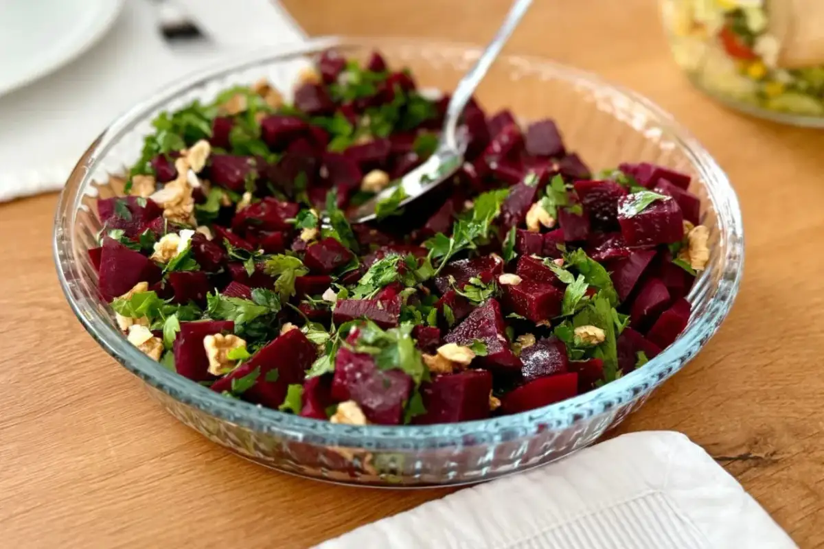 Pyszna sałatka z burakiem, orzechami i natką pietruszki w szklanej misie. Idealna na lekki posiłek.