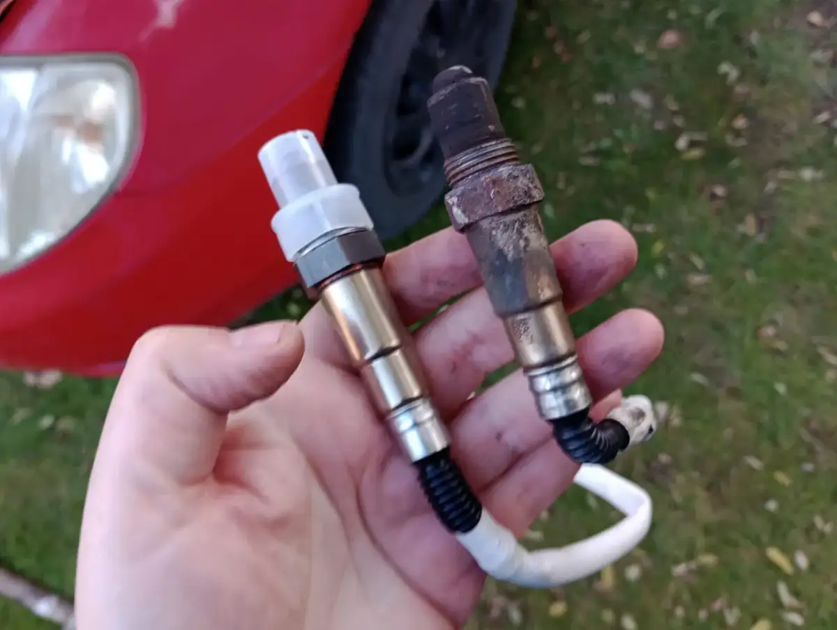 Porównanie nowej i starej sondy lambda. Stara jest okopcona, co może wskazywać na problemy z silnikiem. Dowiedz się, jak sprawdzić sondę lambda.