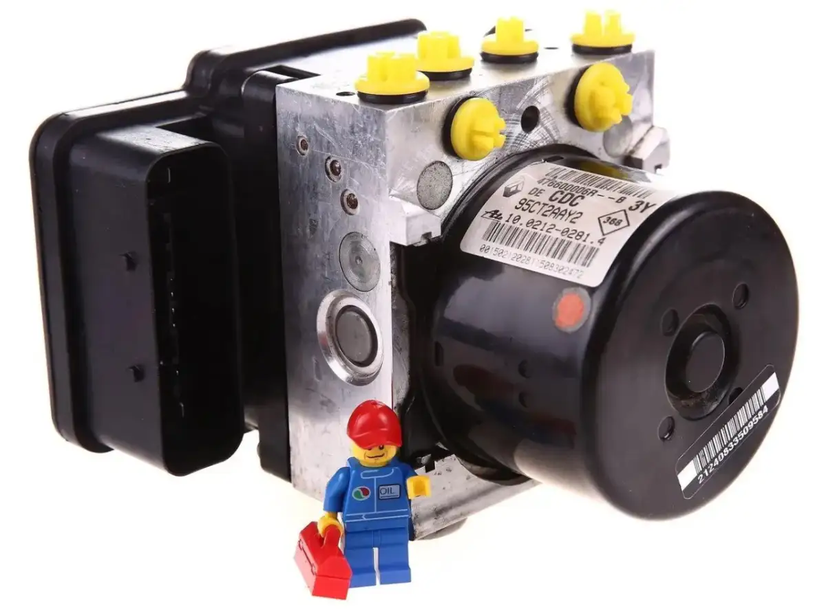 Mini mechanik z walizką przy pompie ABS. Zapowietrzona pompa ABS objawy mogą być różne, ale ten element jest kluczowy dla bezpieczeństwa.