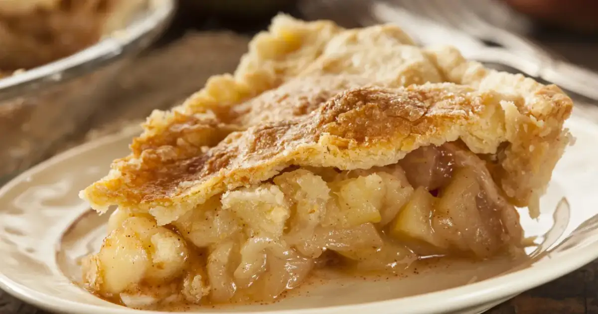Kawałek domowej szarlotki z rumianym ciastem i soczystym jabłkowym nadzieniem. Czy szarlotka jest zdrowa? Zależy od składników, ale jabłka to witaminy!