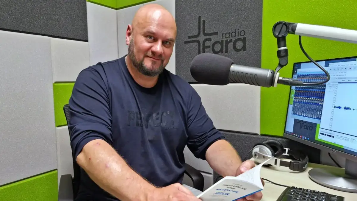 Arkadiusz Łodziewski w studiu Radia Fara, trzymający książkę. Jego życiorys mógłby opowiadać o tej chwili.