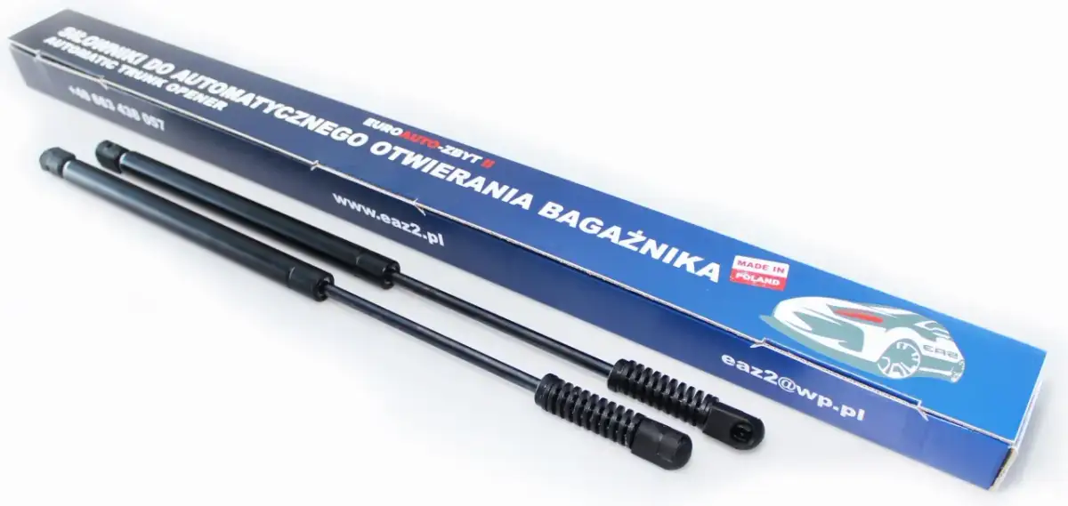 Dwa siłowniki do automatycznego otwierania bagażnika, zapakowane w niebieskie pudełko z napisem "MADE IN POLAND".