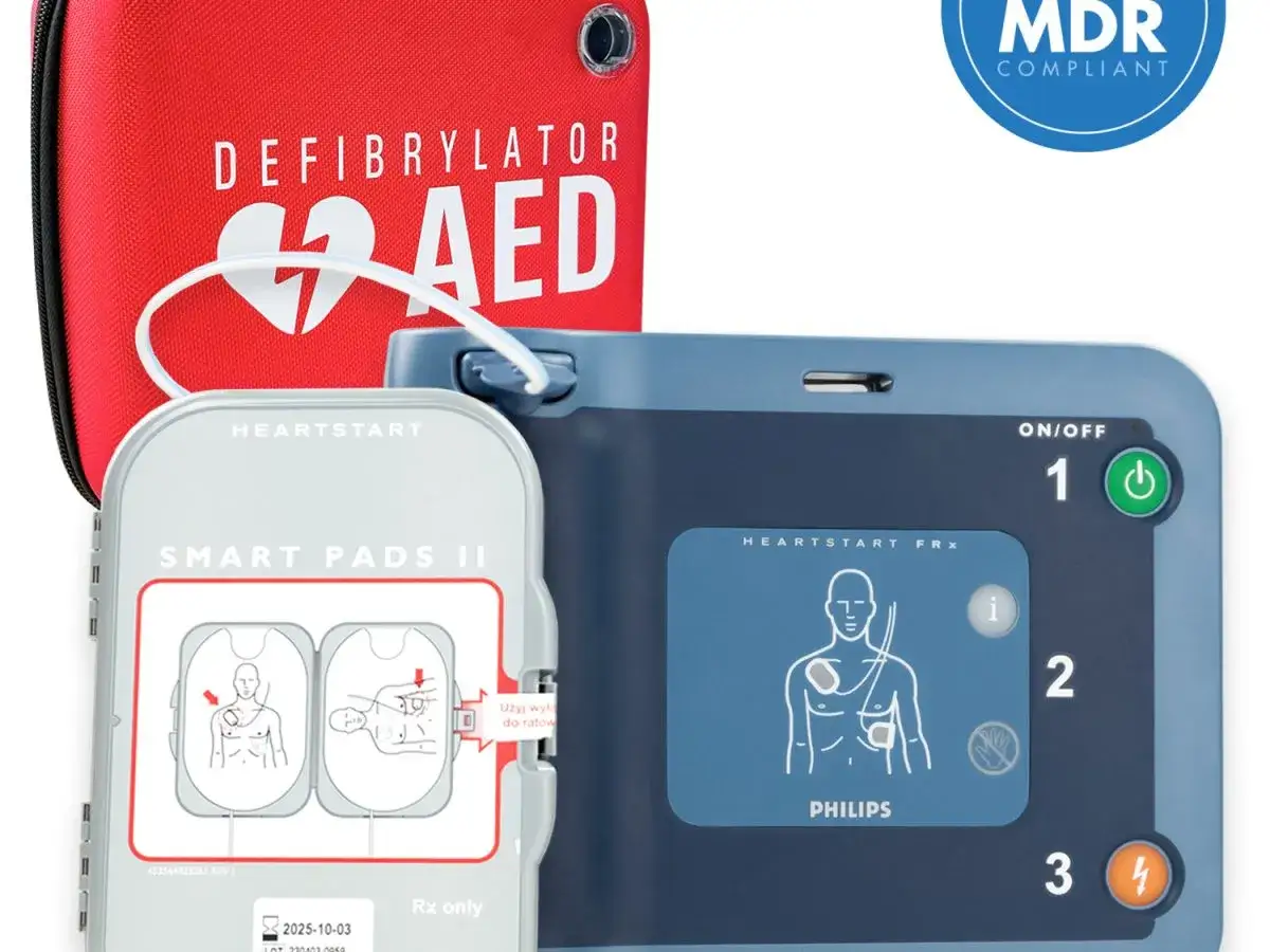 Czerwony pokrowiec z napisem "DEFIBRYLATOR AED" i niebieski defibrylator z elektrodami.