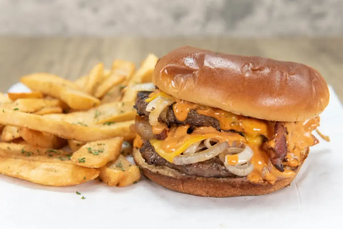 Podwójny burger z serem, bekonem i sosem, podany z frytkami. Idealny na to, na czym smażyć burgera.