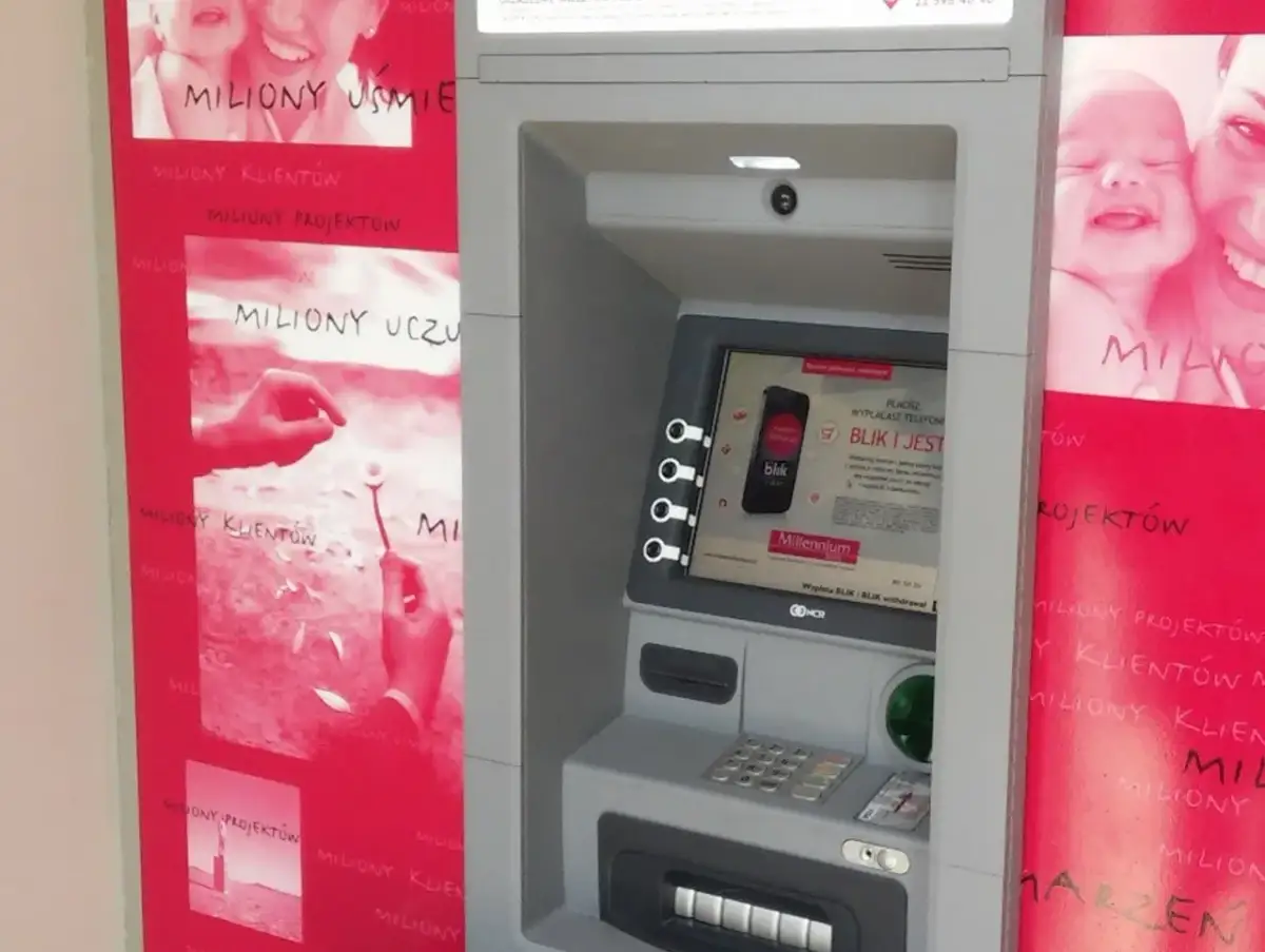 Bankomat Millennium z hasłem "miliony uśmiechów". Obok reklamy z uśmiechniętymi dziećmi i hasłem "miliony uczuć".