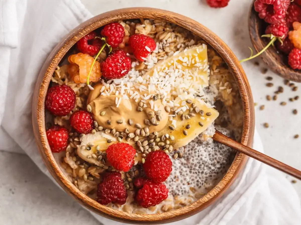 Pyszne śniadanie z chia: owsianka z malinami, bananem, masłem orzechowym i wiórkami kokosowymi.