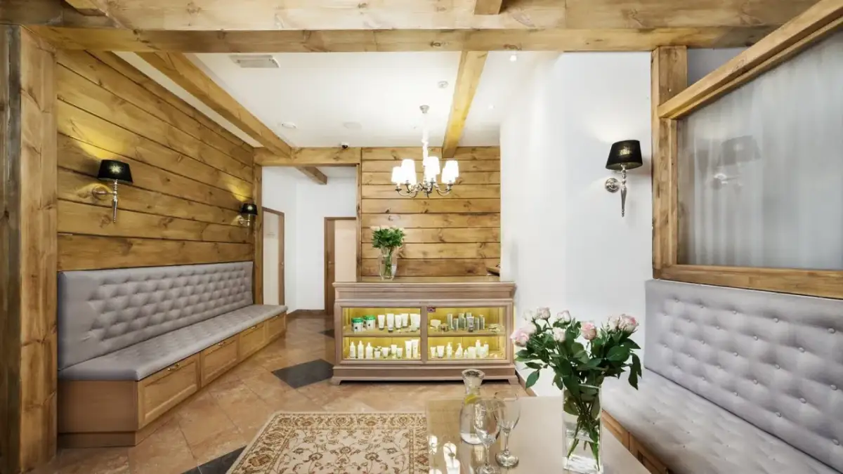 Przytulne wnętrze salonu spa w Białymstoku i okolicach. Drewniane ściany, wygodne ławy i ekspozycja kosmetyków tworzą atmosferę relaksu.