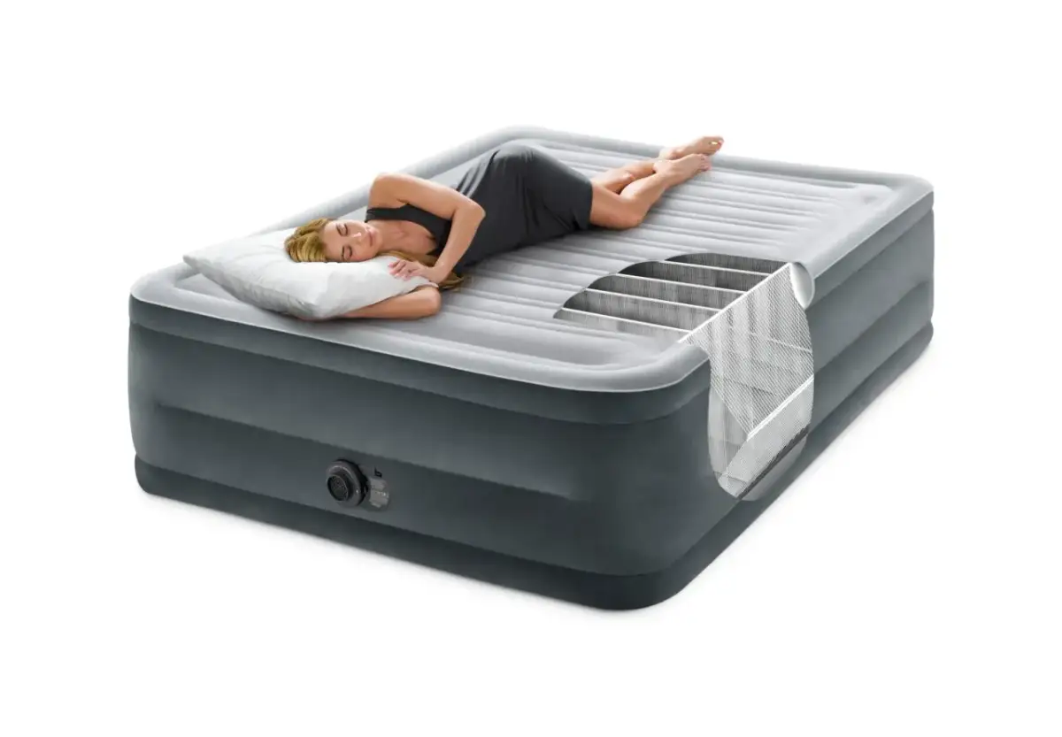 Kobieta śpi na materacu samopompującym. Widoczny przekrój ukazuje jego konstrukcję. Dowiedz się, jak napompować materac samopompujący.