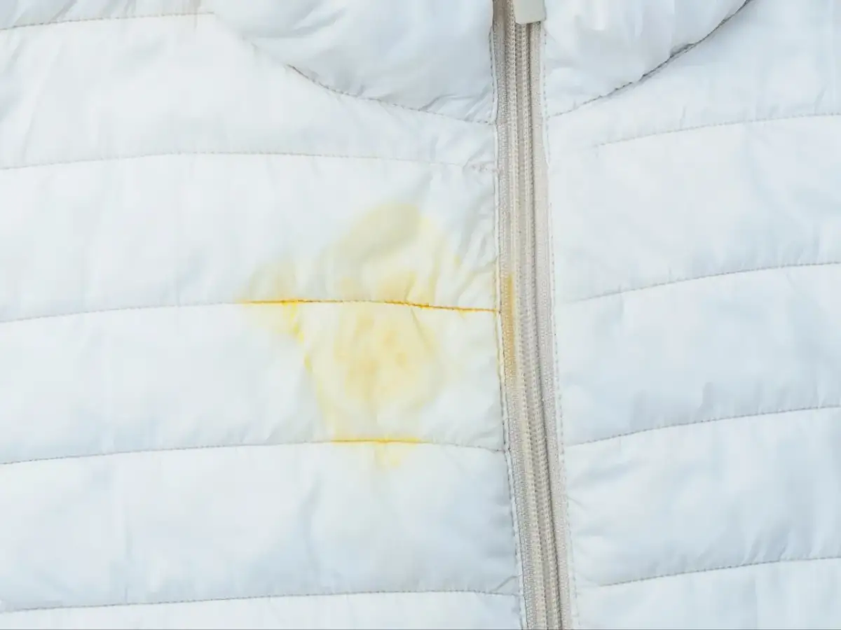 Żółta plama na białej kurtce puchowej. Dowiedz się, jak naprawić kurtkę puchową i usunąć zabrudzenia.