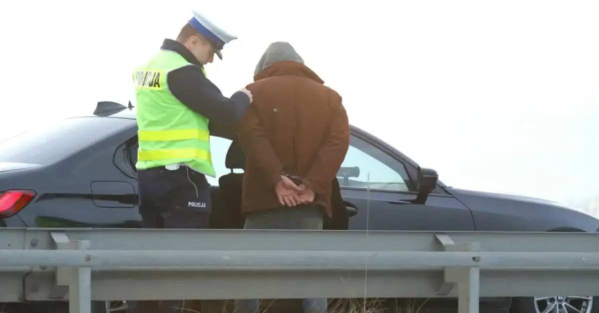 Policjant zakłada kajdanki zatrzymanemu mężczyźnie. Nowelizacja kodeksu karnego w praktyce.