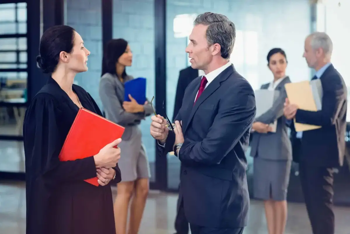 Prawnicy dyskutują, czy po upadłości konsumenckiej można otworzyć działalność gospodarczą. Kobieta w todze trzyma czerwoną teczkę.