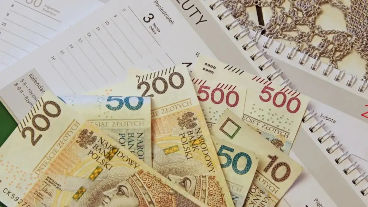 Polskie banknoty o nominałach 10, 50, 200 i 500 zł leżą na kalendarzu.