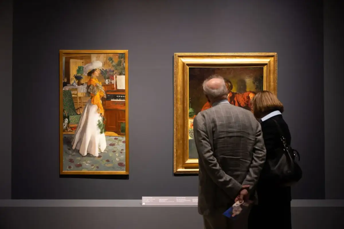 Para zwiedza muzeum sztuk użytkowych, podziwiając obrazy.