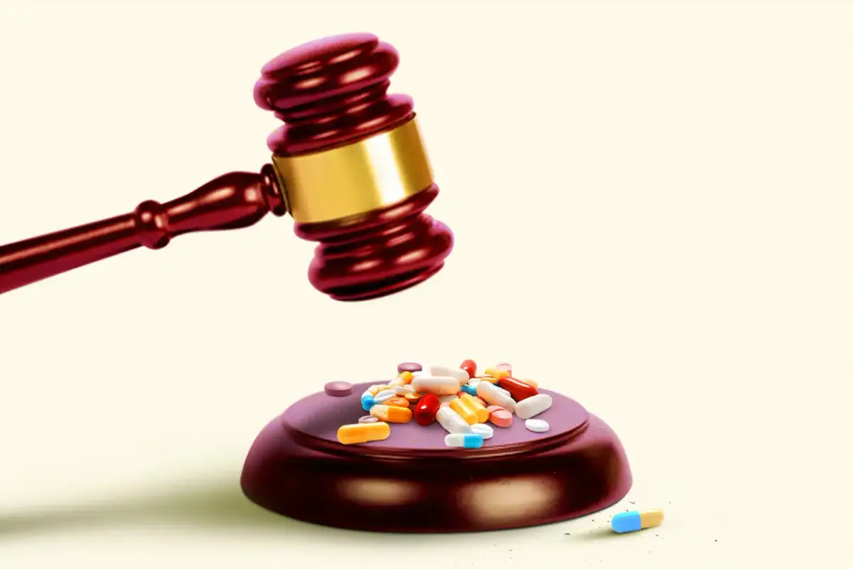 Młotek sędziowski nad stertą pigułek i kapsułek.