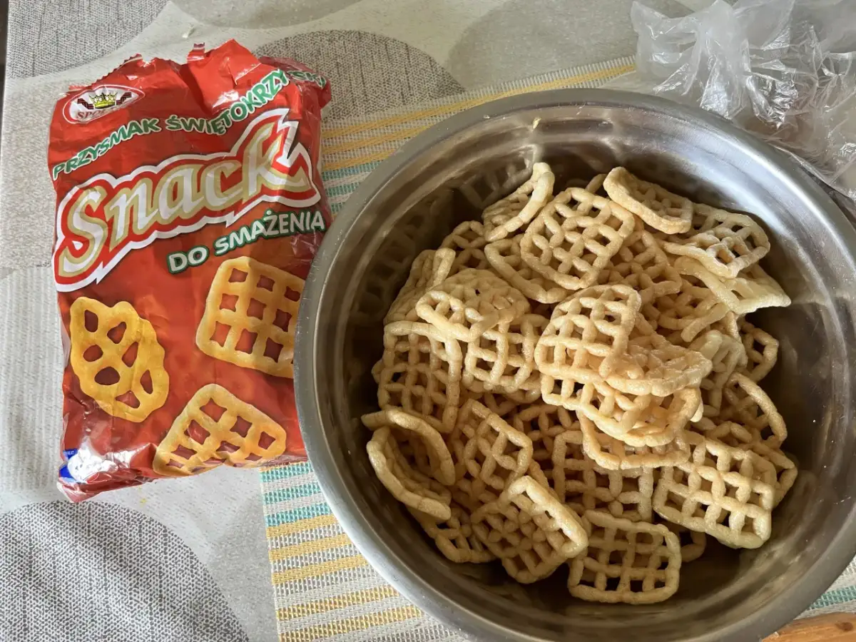 Opakowanie przekąski "Snack" i miska pełna chrupek o kratkowanym kształcie.