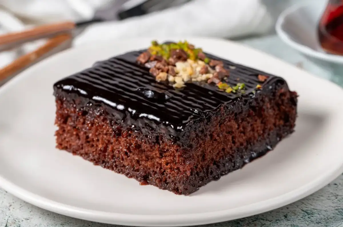 Wilgotne ciasto na oleju, polane błyszczącą polewą czekoladową i posypane orzechami. Idealne na deser.