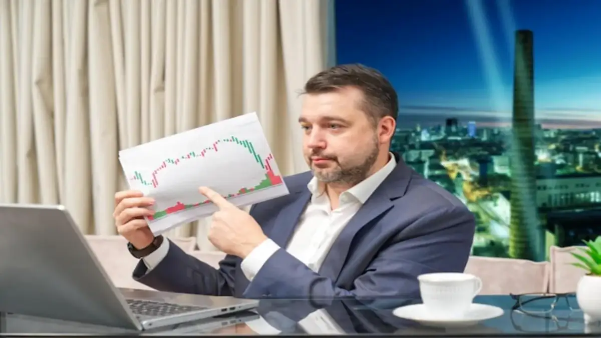 Mężczyzna analizuje wykresy, zastanawiając się, jak zarobić na giełdzie 200 złoty dziennie.