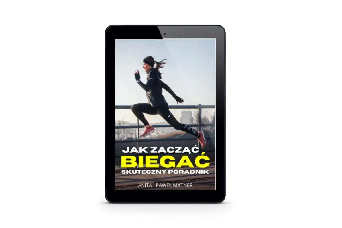 Kobieta w stroju sportowym skacze, na ekranie tabletu widnieje napis "Jak zacząć biegać. Skuteczny poradnik".