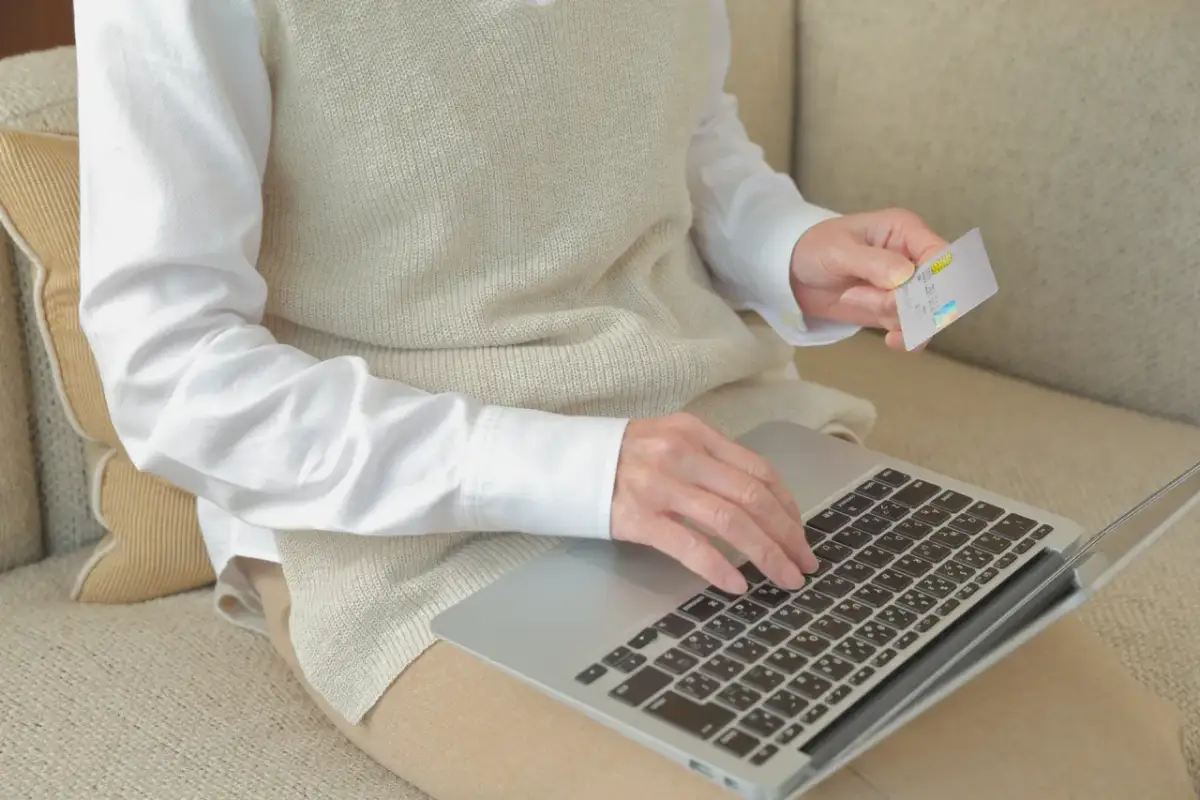 Kobieta z kartą płatniczą na laptopie sprawdza, czy chwilówki są w BIK.