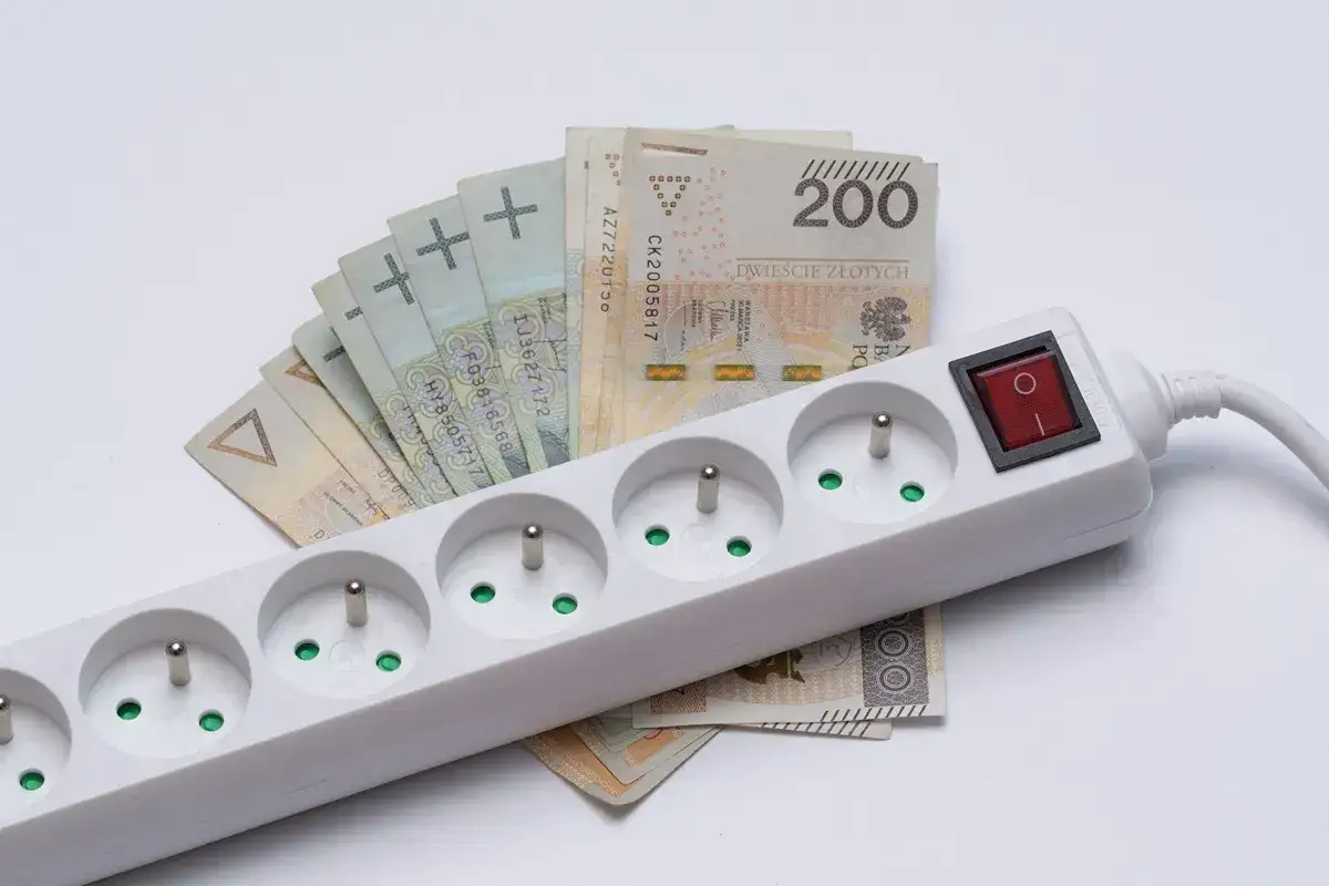 Przedłużacz z polskimi banknotami sugeruje możliwość uzyskania **zniżki na prąd**.