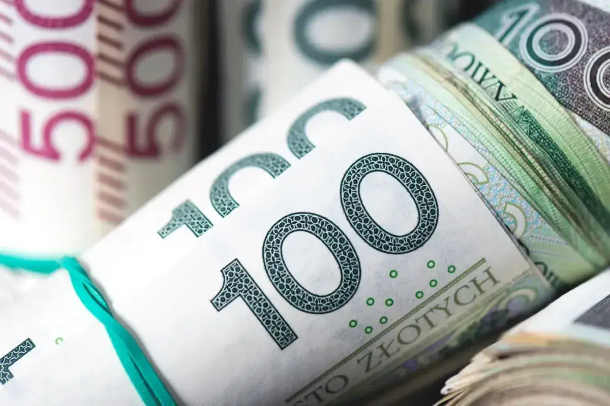 Zwijane banknoty 100 zł i 50 zł związane gumką.