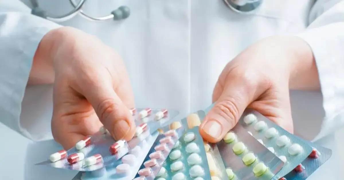 Lekarz pokazuje opakowania tabletek, przypominając o potencjalnych metypred skutki uboczne.