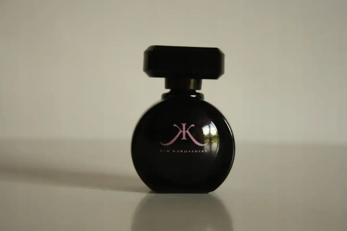Czarna butelka perfum Kim Kardashian z różowym logo.