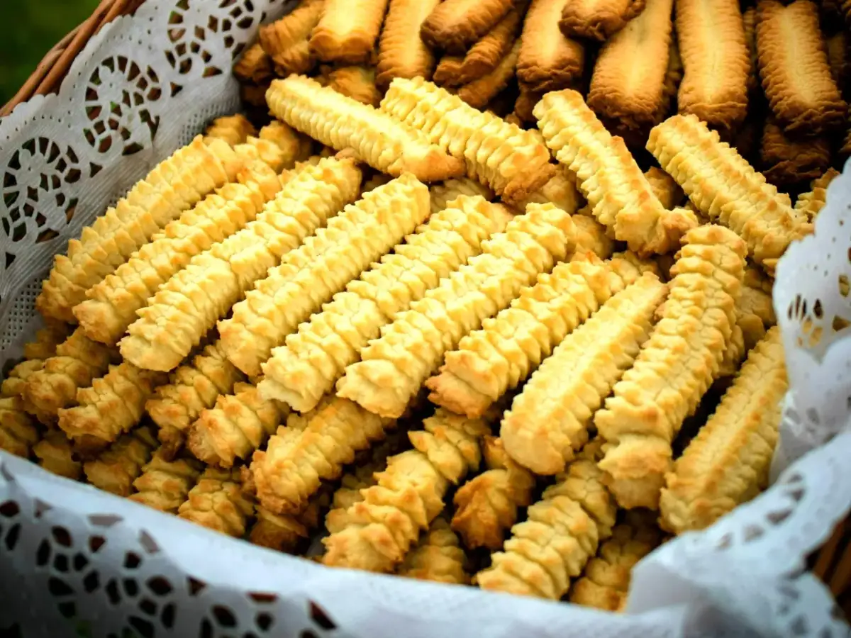 Koszyk pełen domowych, złocistych ciasteczek o charakterystycznym, karbowanym kształcie.