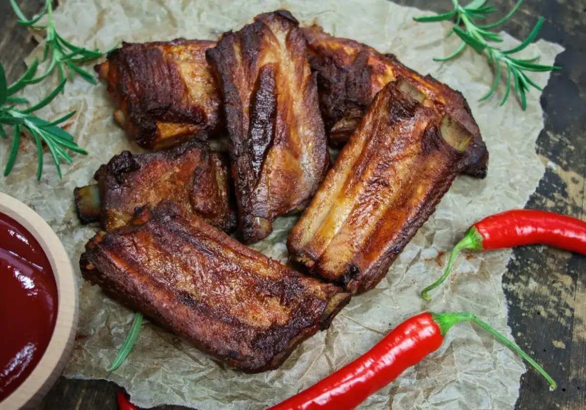 Soczyste żeberka w coli, pieczone do perfekcji, podane z sosem i papryczkami chili.